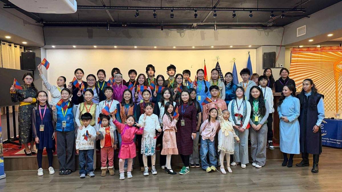 Children in Mongolian dress waving Mongolian flags at a WE Together event